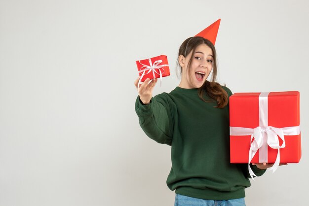 화이트에 그녀의 크리스마스 선물을 보여주는 파티 모자와 함께 행복 한 소녀