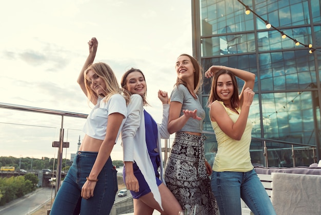 Happy girls dance at a terrace party