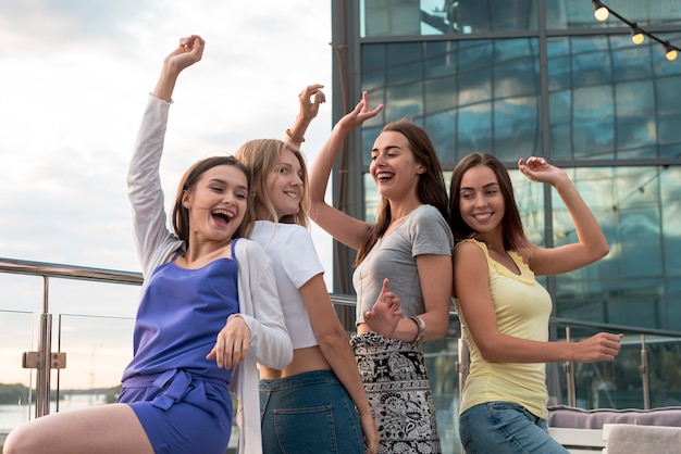 Foto gratuita ragazze felici che ballano schiena contro schiena