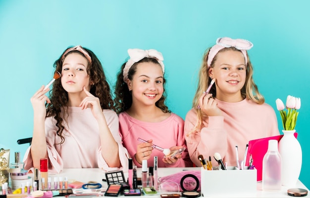 一緒に化粧をしている幸せな女の子姉妹の幸せ化粧品店コントロールオイル口紅を塗るにきびを防ぐ子供の化粧スキンケアの概念子供のための化粧品美容とファッション Premium写真