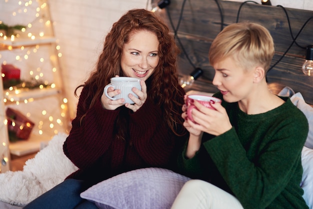 Happy girls drinking tea in bed