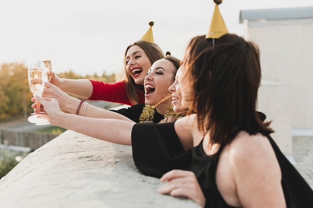 Foto gratuita ragazze felici che fanno festa sul tetto ammirando il tramonto