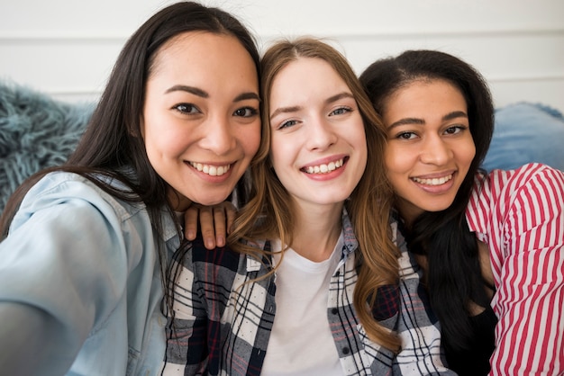 Happy girls taking selfie and smiling looking at camera