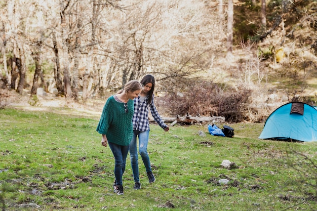 Free photo happy girls walking and leaving the tent