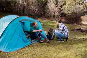 Free photo happy girls with tent in the field