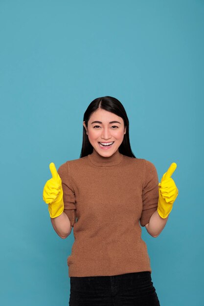 Happy glad and cheerful asian houseworker from chores thumbs up wearing yellow gloves for hand safety, Housewife worker, Cleaning home concept, Smiling satisfied and optimistic woman