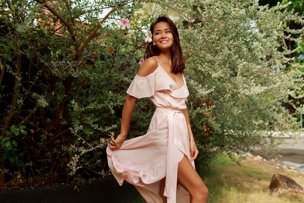 Happy graceful Asian woman walking in the park in summer sunny day.