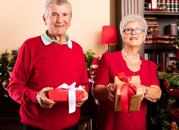 Happy grandparents holding christmas presents