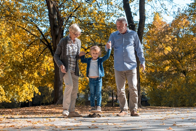 Free photo happy grandparents playing with their grandson in the park