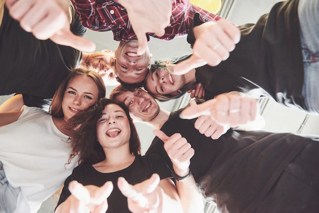 Happy group of friends with their hands together in the middle