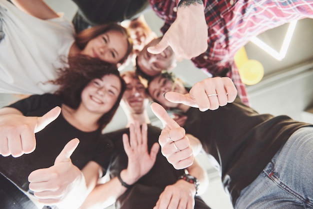 Happy group of friends with their hands together in the middle