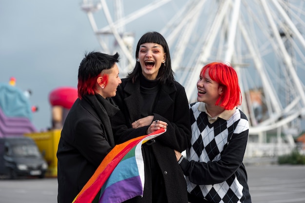 Free photo happy group of non binary people with lgbt flag