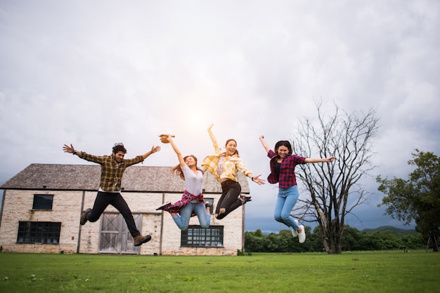 Happy group of teen student jumping in park