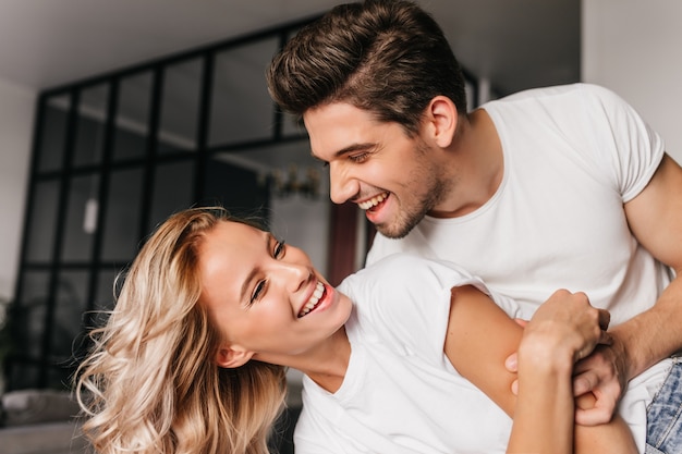 happy guy dancing with girlfriend. smiling young people having fun at home.