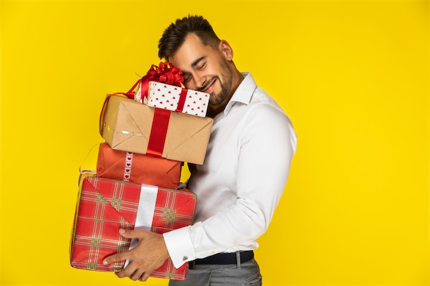 Free photo happy guy holding boxes with gifts