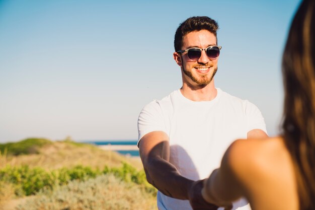 Happy guy holding hands of girlfriend