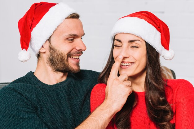 Happy guy holding lady's nose 