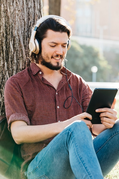 Felice ragazzo utilizzando uno smartphone per ascoltare musica con le cuffie