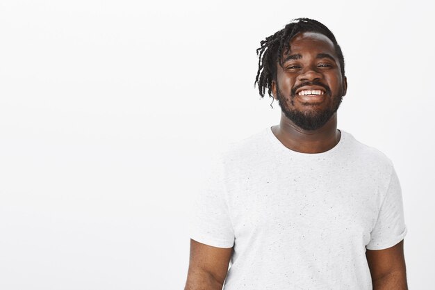 happy guy with braids posing against the white wall