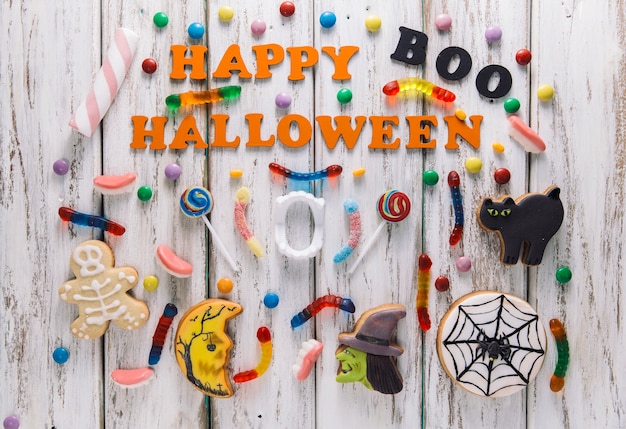 Happy Halloween caption with candies and cookies