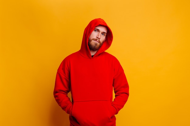 Happy handsome brutal bearder man wearing warm red winter trendy fleece hoodie