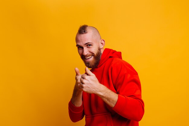 Happy handsome brutal bearder man wearing warm red winter trendy fleece hoodie