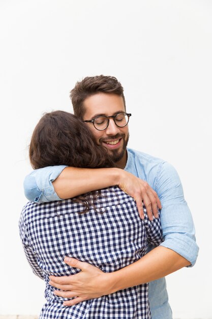 Happy handsome guy embracing girlfriend