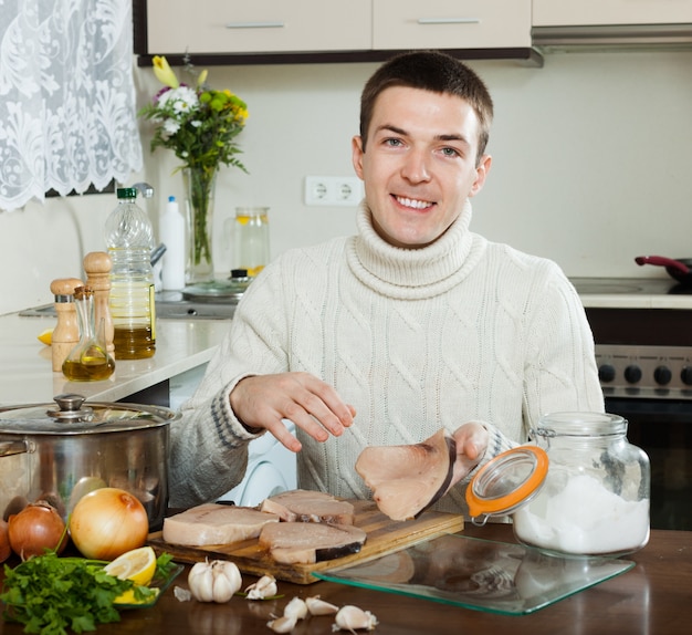 Happy handsome man cooking steak of porbeagle