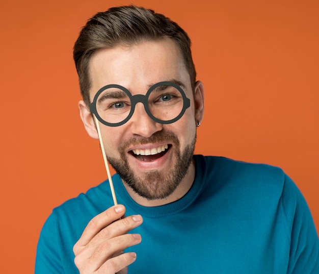 Happy handsome man posing with fake glasses