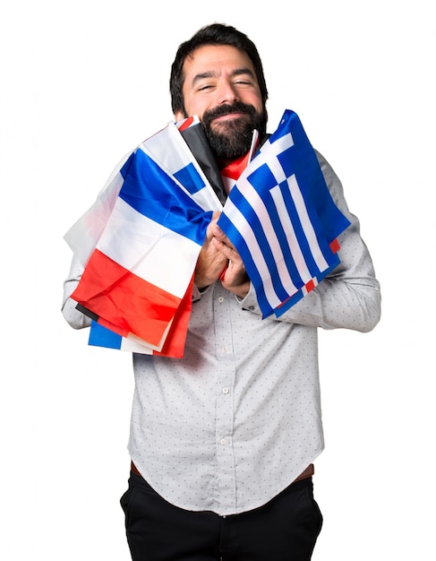 Happy handsome man with beard holding many flags