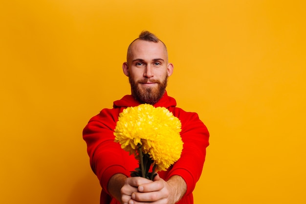 Happy handsome man with flowers bouquet of yellow asters