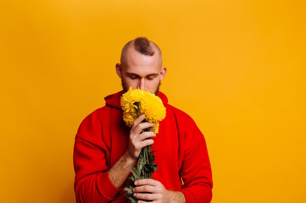 Happy handsome man with flowers bouquet of yellow asters