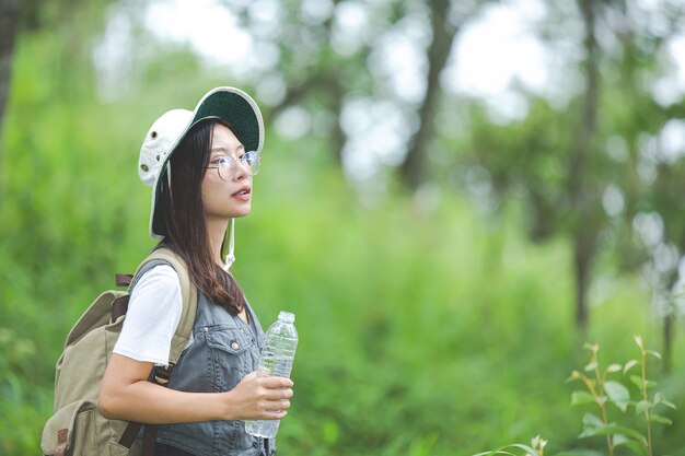 A happy hiker walks through the jungle with a backpack.