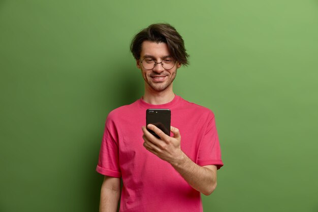 Happy hipster guy uses mobile phone application