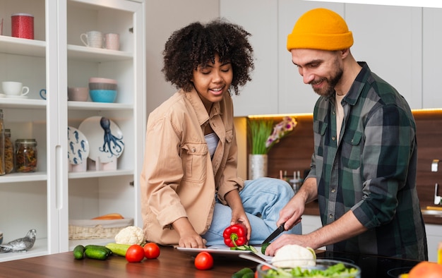 Happy hipster man cutting vegetables