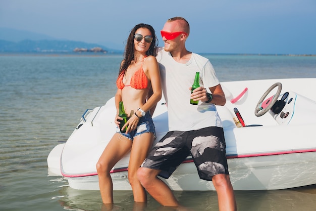 幸せな流行に敏感な女性と男性が海でボートに乗って旅行するタイの夏の熱帯休暇、ビーチでのパーティー、一緒に楽しむ人々、前向きな感情でビールを飲む