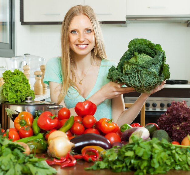 happy housewife  with raw cabbage in home kitchen