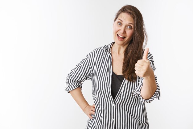 Happy and impressed gorgeous middle-aged woman showing thumb-up