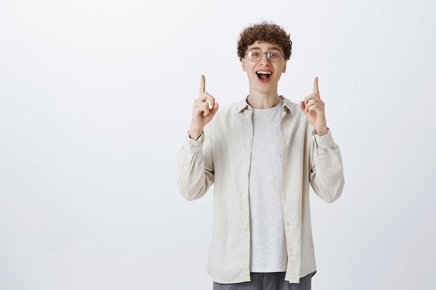 Foto gratuita ragazzo adolescente impressionato felice che posa contro il muro bianco