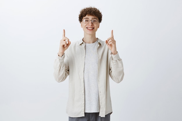 Happy impressed teenage guy posing against the white wall