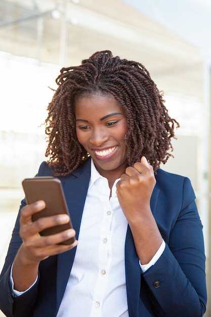 Happy joyful business woman holding cellphone