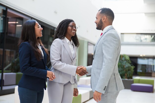 Happy joyful diverse business partners greeting each other