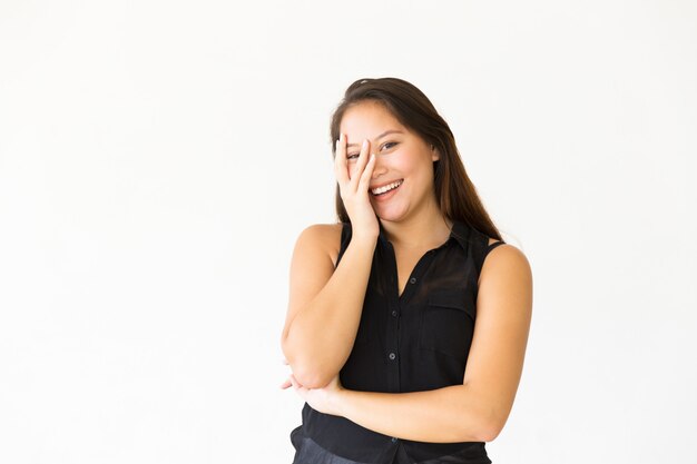 Happy joyful teenage girl touching face with palm