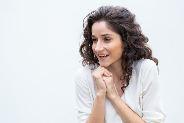 Donna allegra felice con distogliere lo sguardo delle mani giunte