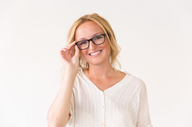 Happy joyful young woman adjusting her glasses