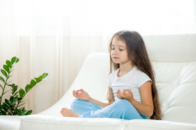Счастливый ребенок девочка делает йога дома