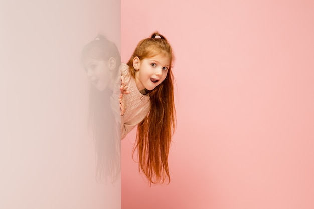 Happy kid, girl isolated on coral pink