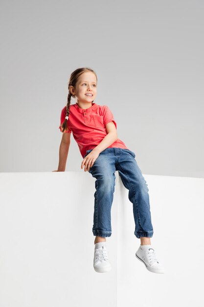 Happy kid girl isolated on white studio background Looks happy cheerful sincere Copyspace Childhood education emotions concept