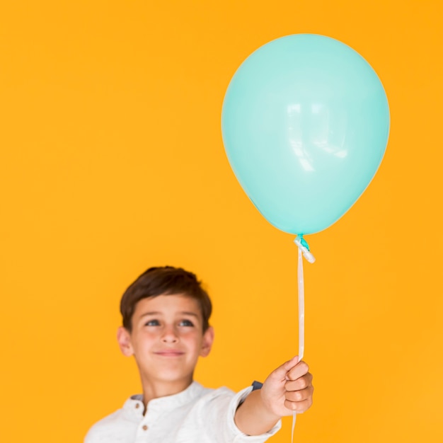 Happy kid holding a blue balloon