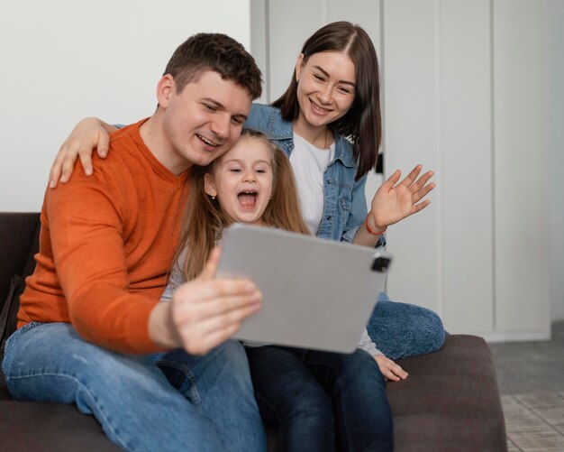 Bambino felice e genitori con tablet